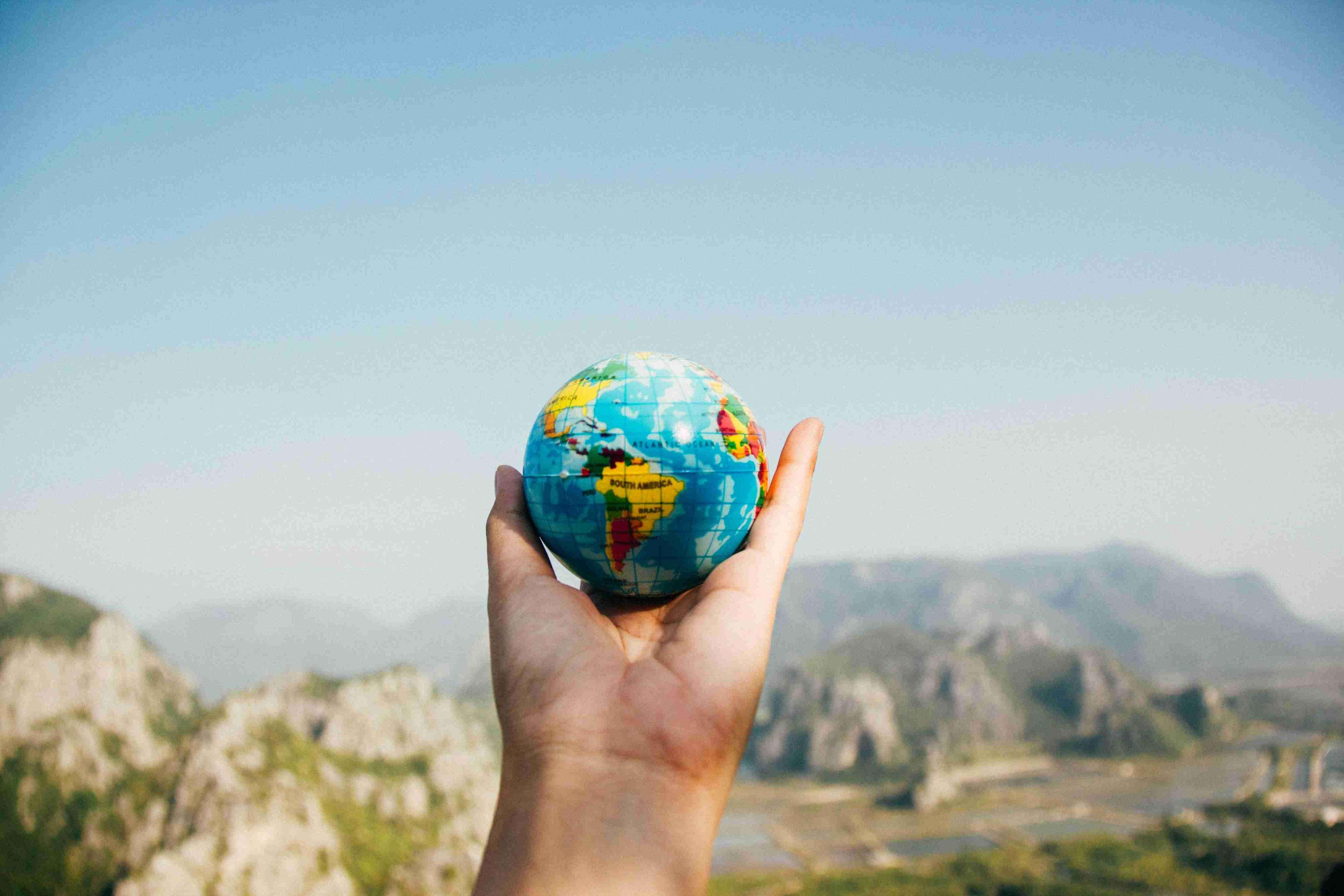 Hand holding a globe - committed to a cleaner tomorrow